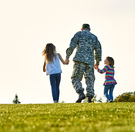 Service member walking with family, representing military and veteran families we support